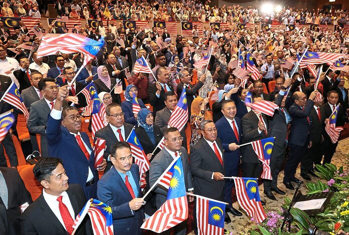 State government officers raising the flag at the Kempen Kibar Jalur Gemilang launch at Auditorium Dewan Jubli Perak in Bangunan Sultan Abdul Aziz, Shah Alam.